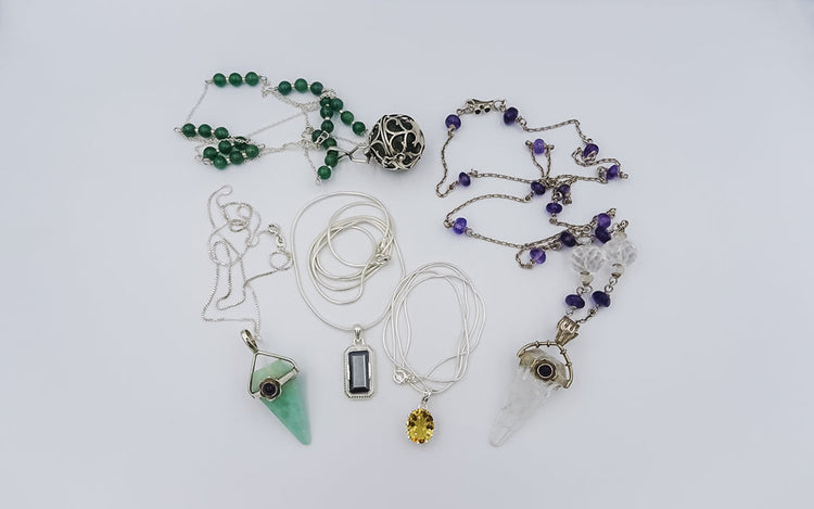 A collection of silver necklaces featuring various gemstone pendants, unique jewelry pieces .